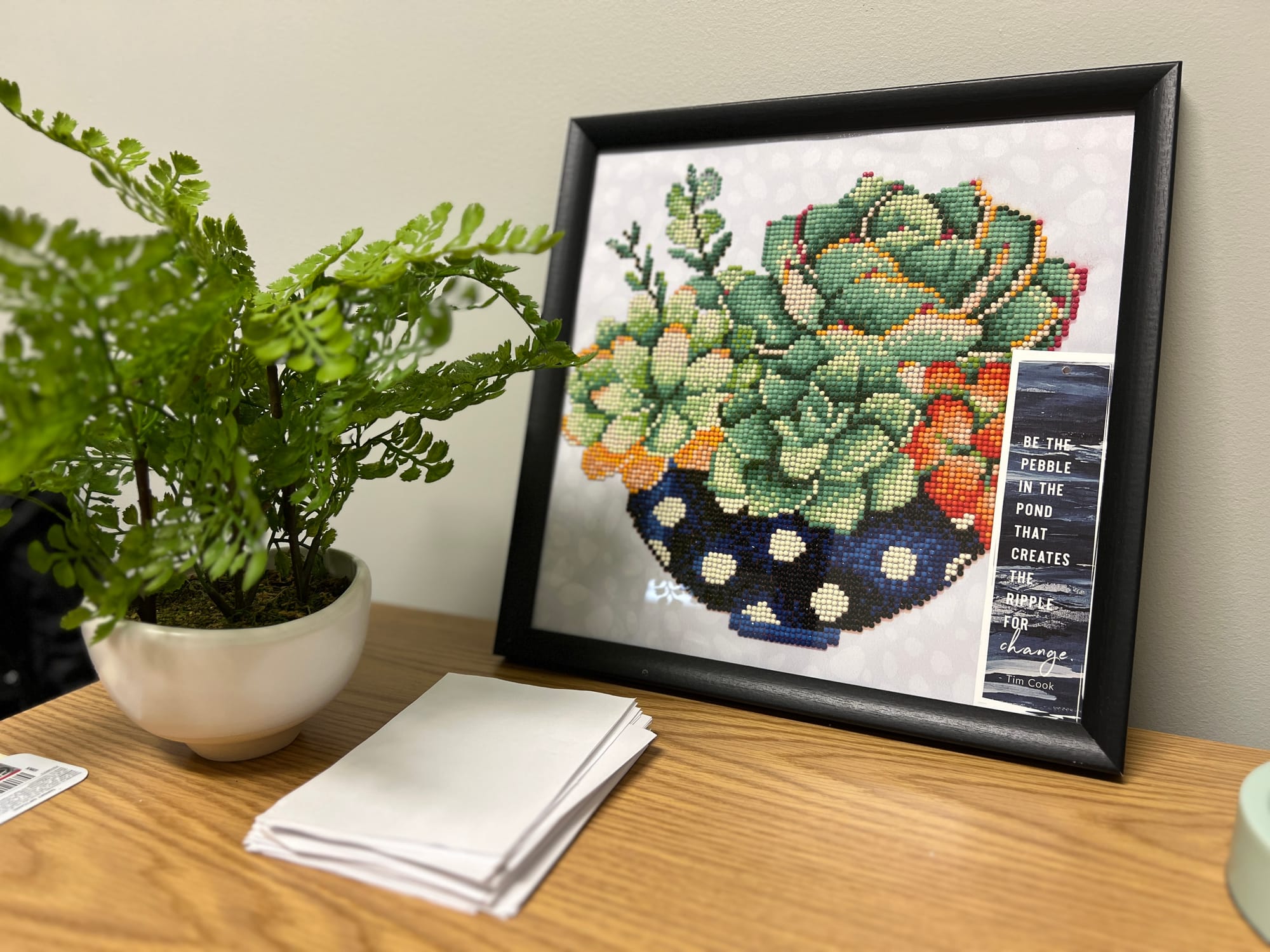 View of a plant and an image of a plant on a desk with an inspirational quote.