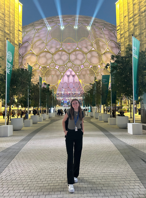 Young woman poses for a photo at COP28 conference.