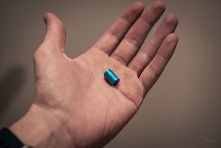 Man's hand holds 3D-printed uranium pellet.