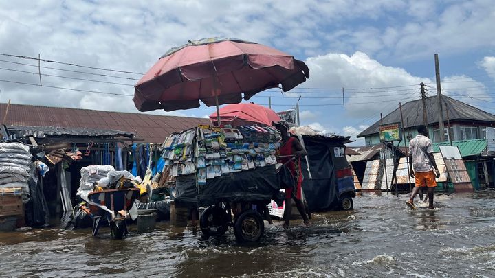 A man pushes a cart across the street as flood water continues to displace people in Yenagoa Nigeria, October 18, 2022. (REUT
