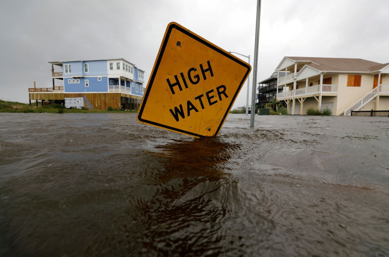 Flood waters lap at a high water warning sign that was partially pushed over by Hurricane Florence on Oak Island, North Carolina, on September 15, 2018. (REUTERS/Jonathan Drake TPX IMAGES OF THE DAY)